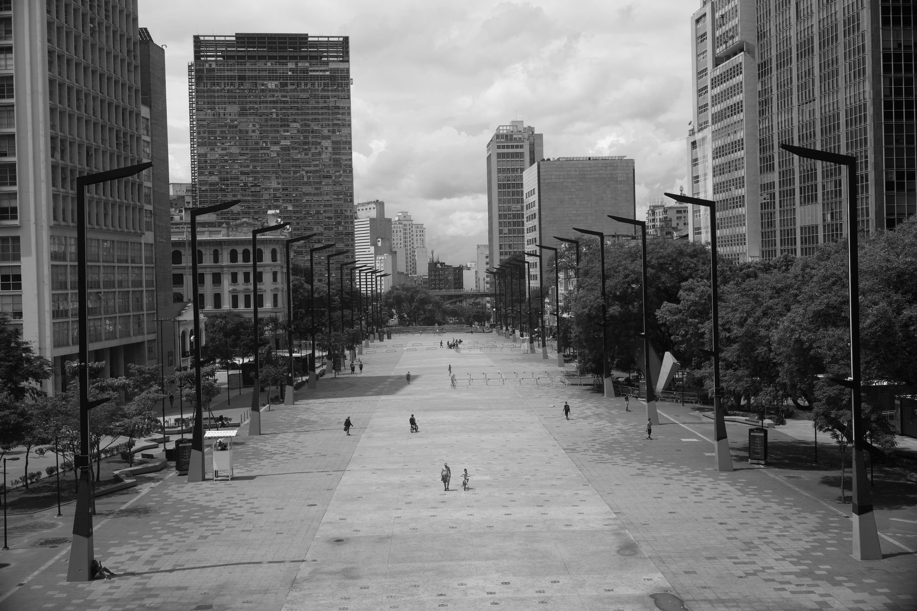 Urban plaza with people moving through city space — black and white cityscape