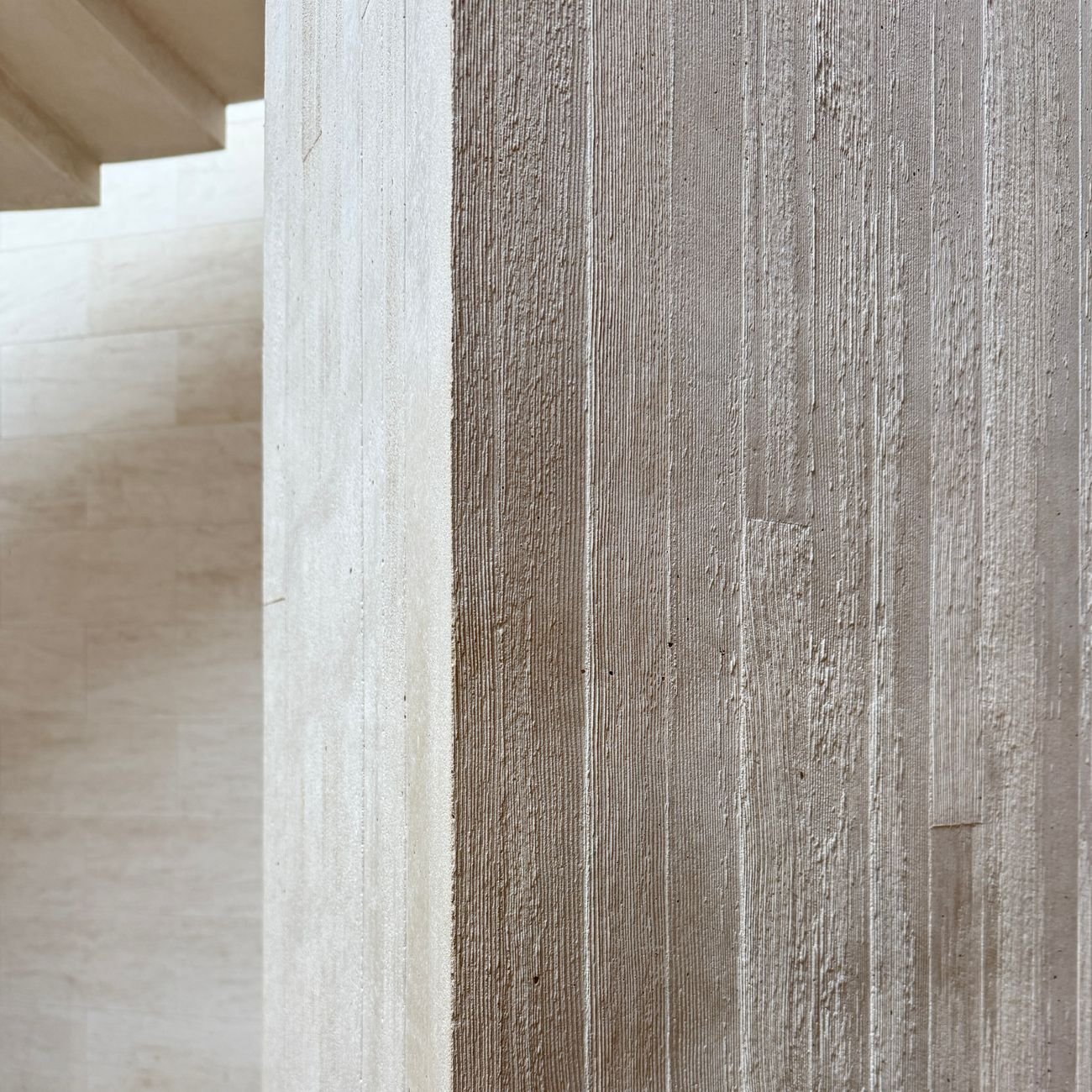Close-up of textured concrete pillar in a modern interior — architectural material detail